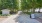 a sidewalk with trees and a sign